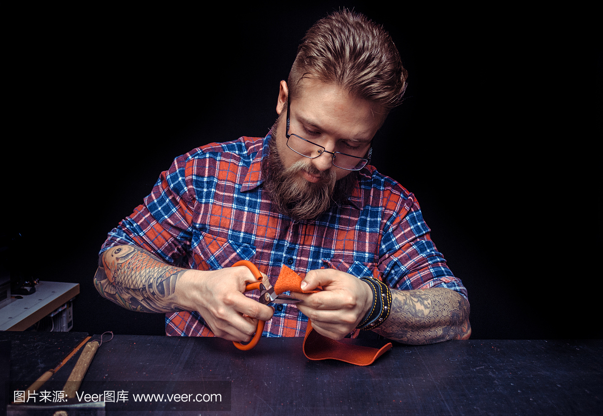 在他的办公桌上用皮革制品制作皮革制品的工匠